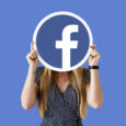 Woman showing a Facebook icon